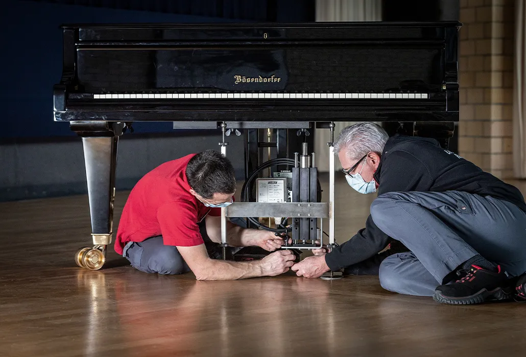Due collaboratori di Orthotec durante la fase di costruzione dell’azionatore per il pedale del piano.